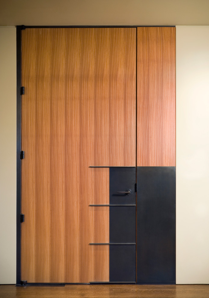 This is an example of a contemporary entryway in Seattle with white walls and a medium wood front door.