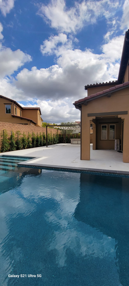 Large contemporary backyard l-shaped lap pool in Orange County with with a pool and tile.