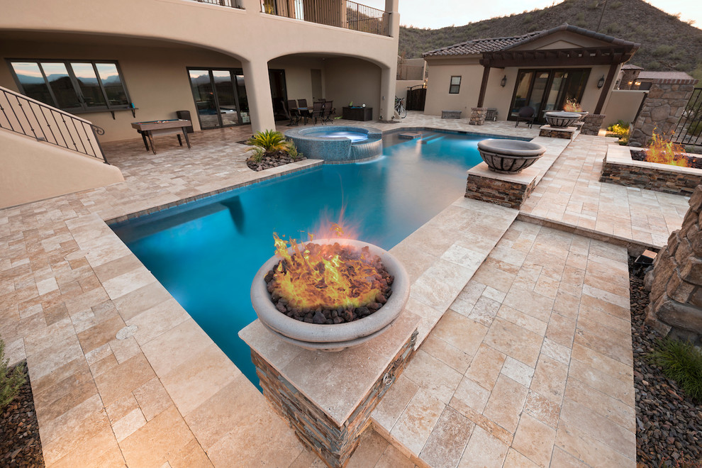 Example of a large minimalist backyard stone and custom-shaped pool fountain design in Phoenix