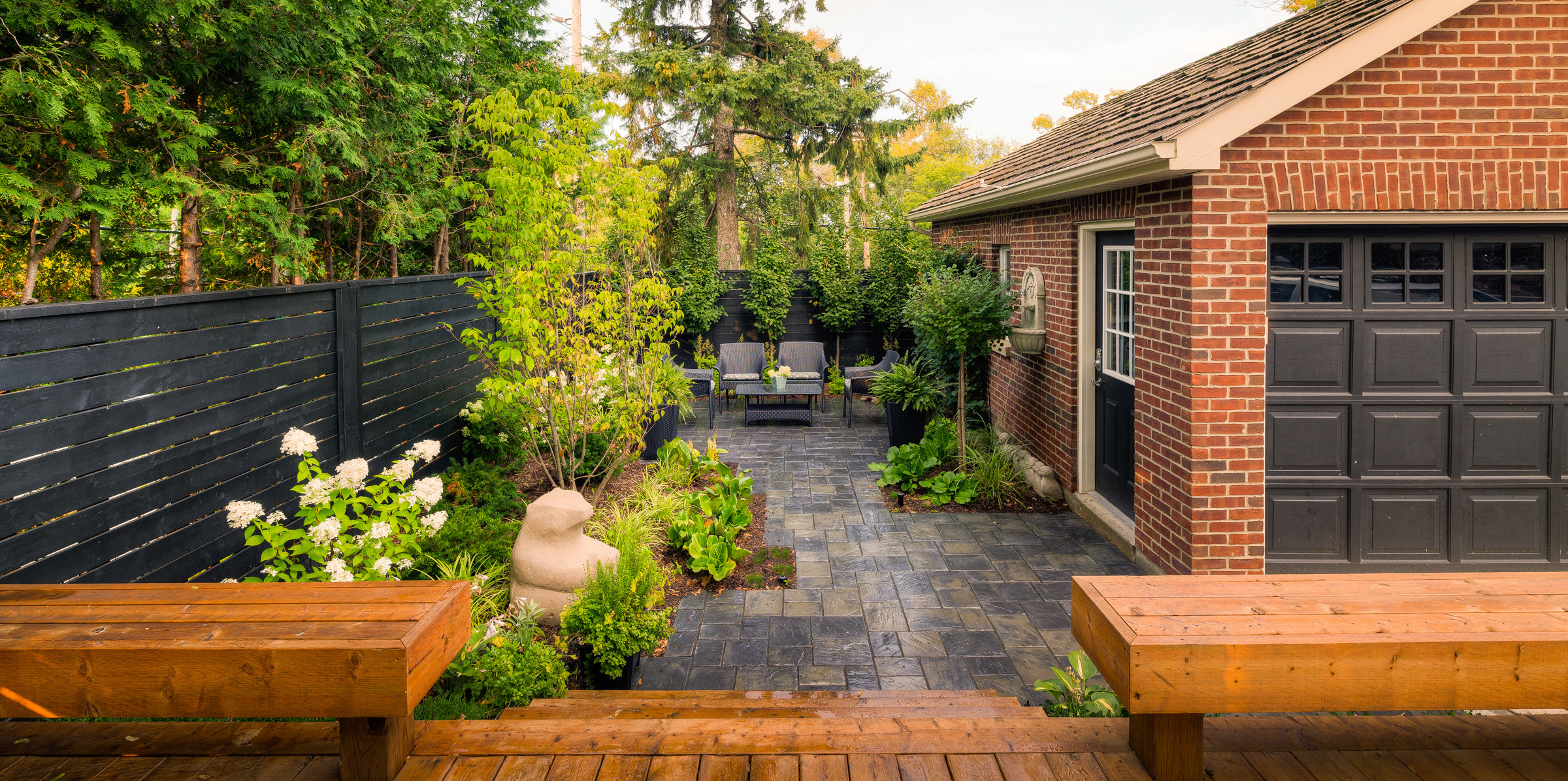 This is an example of a mid-sized eclectic partial sun backyard concrete paver landscaping in Toronto.