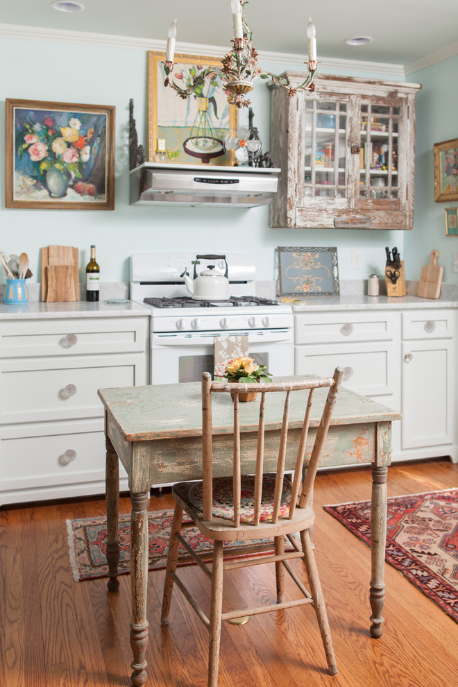 Inspiration for a traditional eat-in kitchen in Wilmington with recessed-panel cabinets, distressed cabinets, white appliances and marble benchtops.