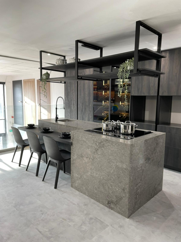 Inspiration for a mid-sized industrial single-wall kitchen in Kent with quartzite benchtops, black appliances, with island, grey floor, grey benchtop, an integrated sink, flat-panel cabinets, dark wood cabinets and vinyl floors.