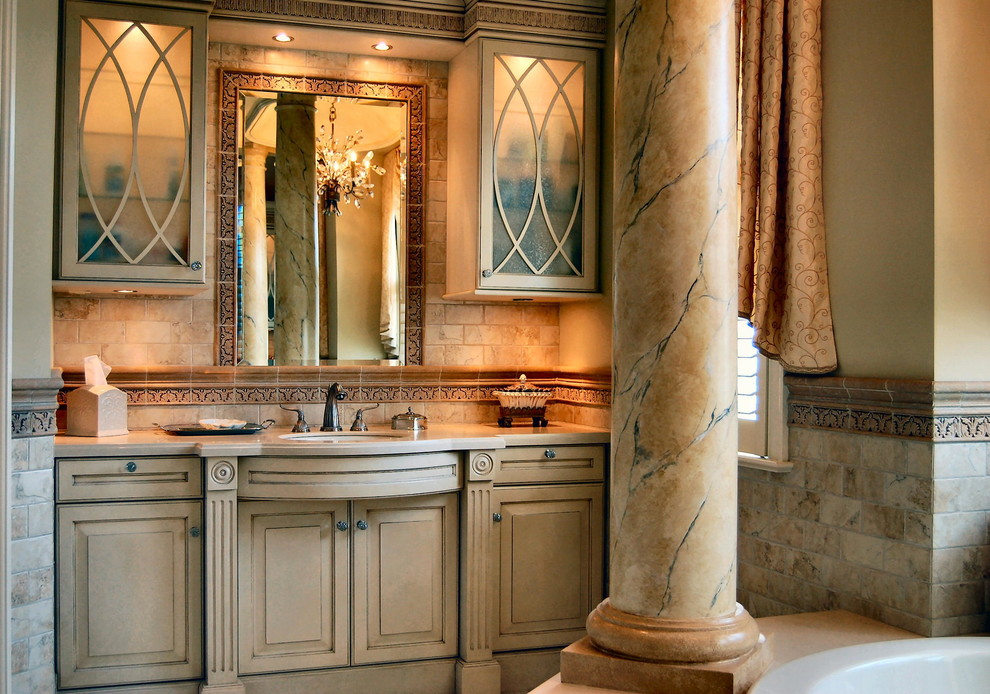 Large traditional master bathroom in Philadelphia with raised-panel cabinets, beige cabinets, a drop-in tub, beige tile, ceramic tile, an undermount sink, marble benchtops and beige walls.