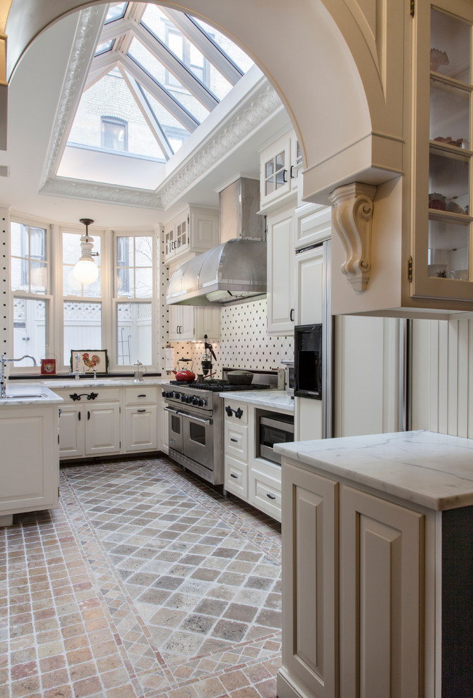 Photo of a traditional u-shaped separate kitchen in New York with raised-panel cabinets, white splashback and panelled appliances.