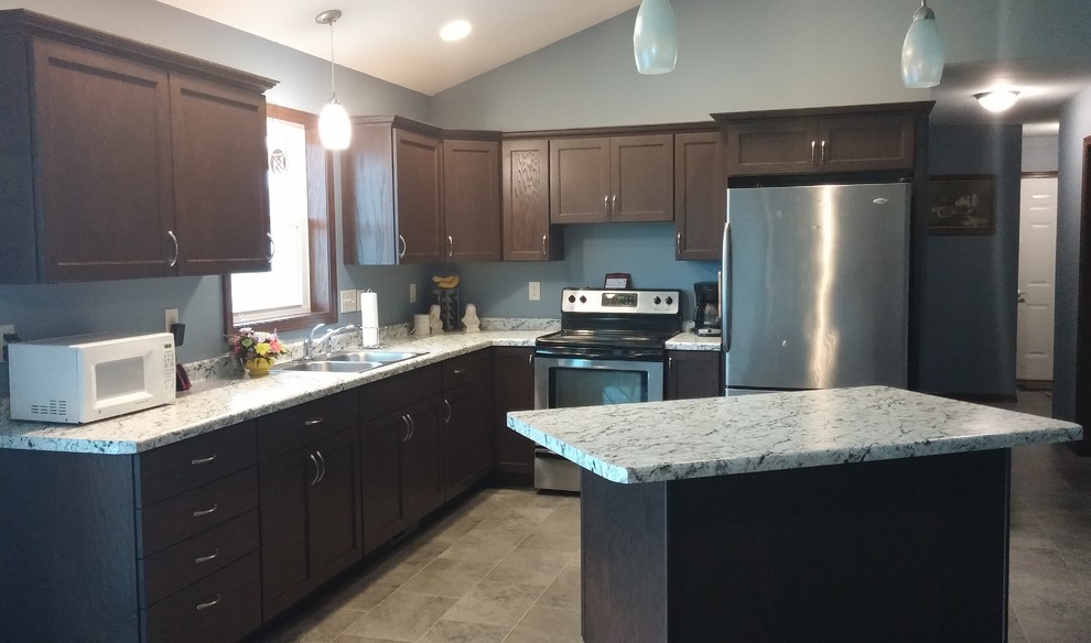 Transitional l-shaped kitchen photo with a drop-in sink, shaker cabinets, laminate countertops and an island