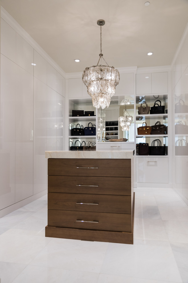 Photo of a large traditional women's walk-in wardrobe in Miami with flat-panel cabinets, marble floors, white cabinets and white floor.