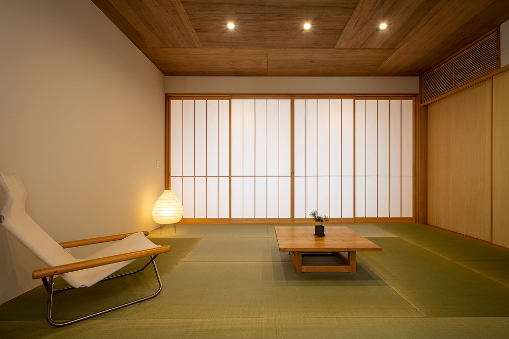 Exemple d'une grande salle de séjour fermée avec un mur beige, un sol de tatami, aucune cheminée, un téléviseur indépendant, un sol vert, un plafond en bois et du papier peint.