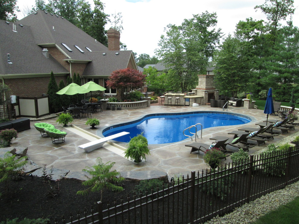Inspiration for a mid-sized transitional backyard custom-shaped lap pool in Other with natural stone pavers.
