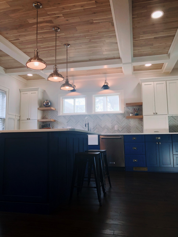 Large classic u-shaped kitchen/diner in Indianapolis with a belfast sink, shaker cabinets, blue cabinets, quartz worktops, grey splashback, ceramic splashback, stainless steel appliances, dark hardwood flooring, an island, brown floors, white worktops and a timber clad ceiling.
