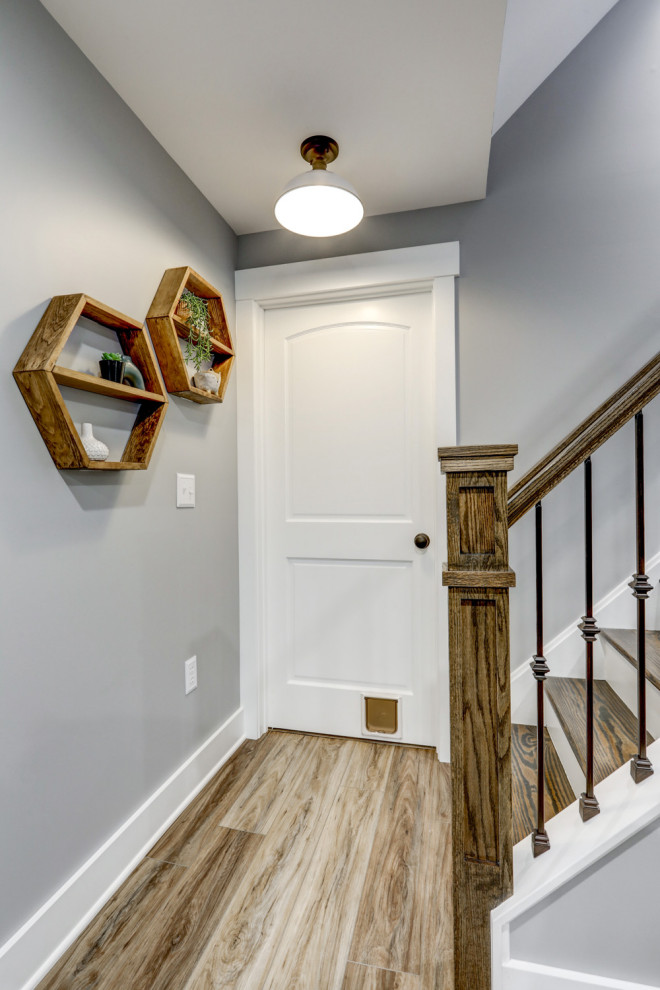 Large transitional walk-out vinyl floor and brown floor basement photo with gray walls
