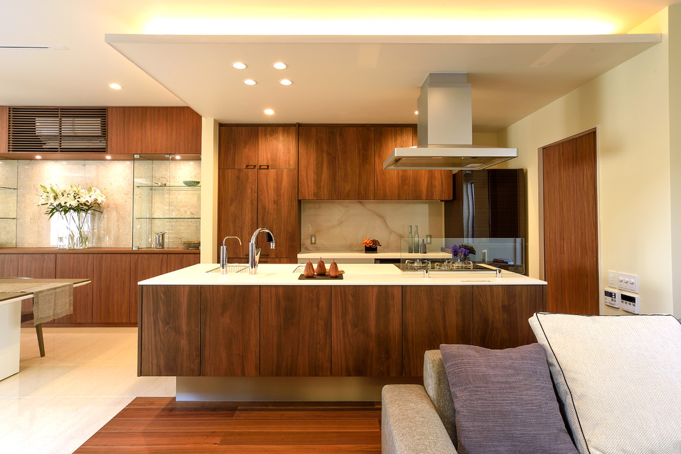 This is an example of a contemporary single-wall open plan kitchen with an integrated sink, flat-panel cabinets, medium wood cabinets, with island and beige floor.
