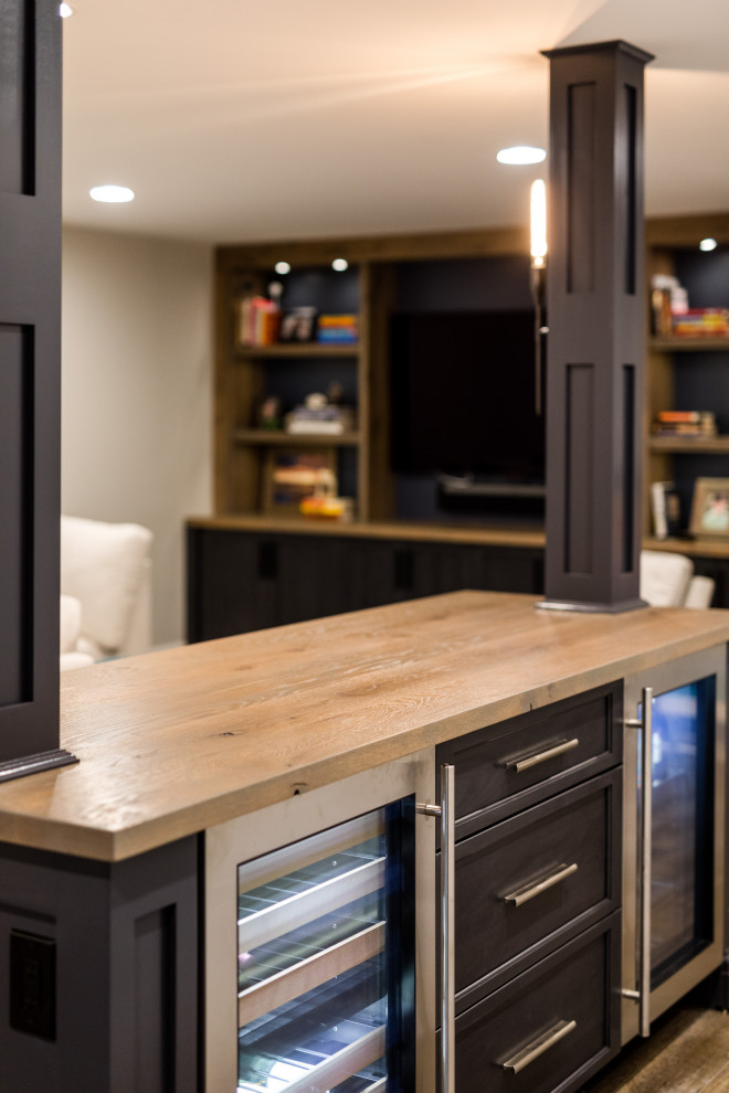 Example of a large transitional underground laminate floor and brown floor basement design with gray walls and no fireplace