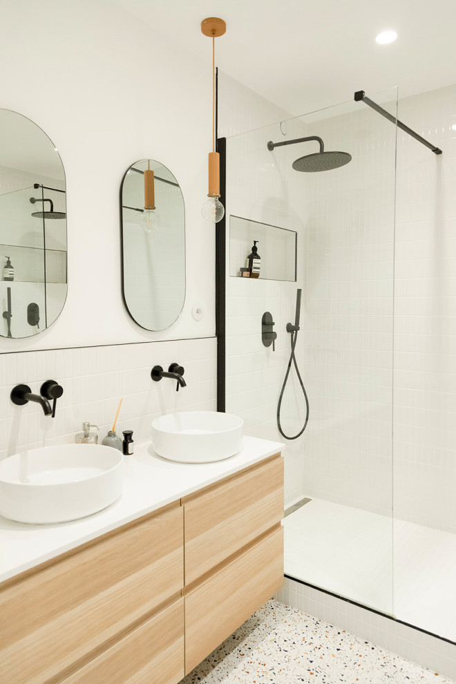 Inspiration for a mid-sized contemporary master bathroom in Paris with flat-panel cabinets, light wood cabinets, a curbless shower, white tile, ceramic tile, white walls, terrazzo floors, a vessel sink, laminate benchtops, white floor, white benchtops, a niche, a double vanity and a floating vanity.