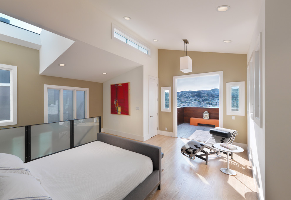 This is an example of a contemporary loft-style bedroom in San Francisco with beige walls, light hardwood floors, no fireplace and beige floor.