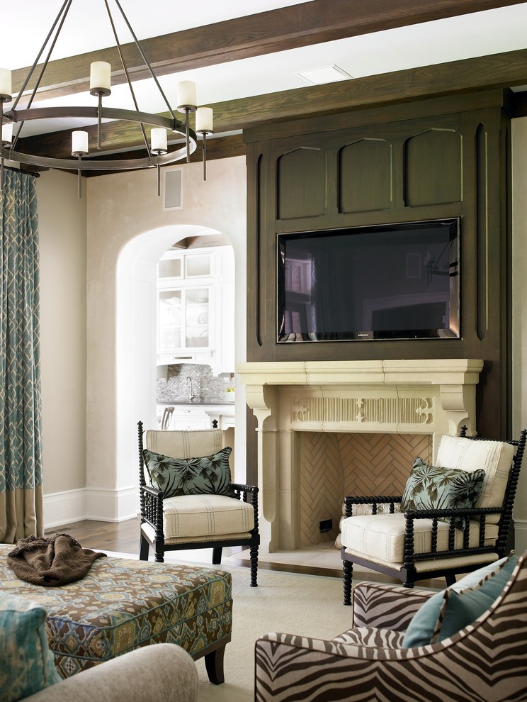 Inspiration for a mid-sized traditional family room in Atlanta with beige walls, a standard fireplace, a plaster fireplace surround and a wall-mounted tv.