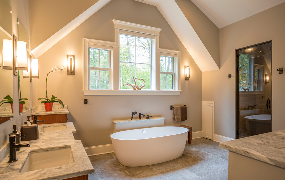 Photo of a large transitional master bathroom in Boston with granite benchtops, a freestanding tub, ceramic floors, shaker cabinets, medium wood cabinets, beige tile, black tile, black and white tile, multi-coloured tile, beige walls and an undermount sink.