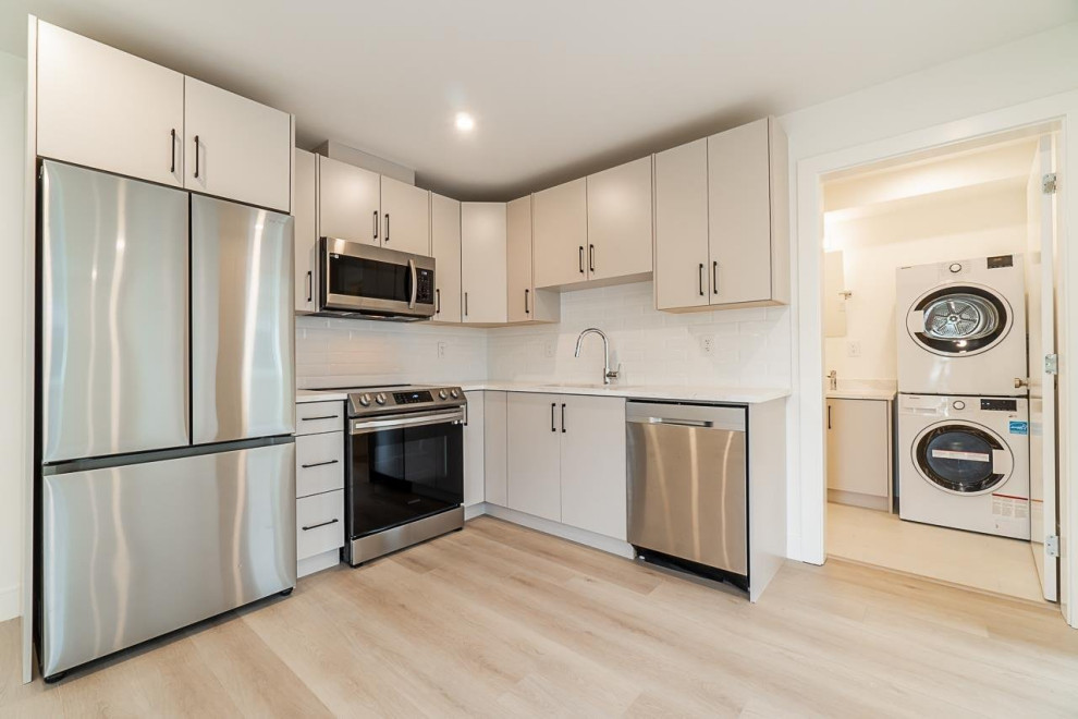 Example of a mid-sized transitional walk-out vinyl floor and beige floor basement design in Vancouver with white walls and no fireplace