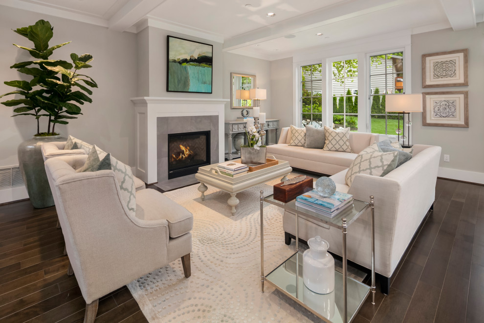 This is an example of a large transitional formal open concept living room in Seattle with grey walls, medium hardwood floors, a standard fireplace, a tile fireplace surround, no tv, brown floor and coffered.