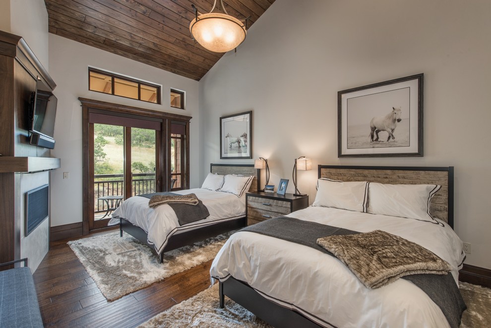 Inspiration for a small transitional guest bedroom in Salt Lake City with grey walls, dark hardwood floors, a standard fireplace, a wood fireplace surround and brown floor.