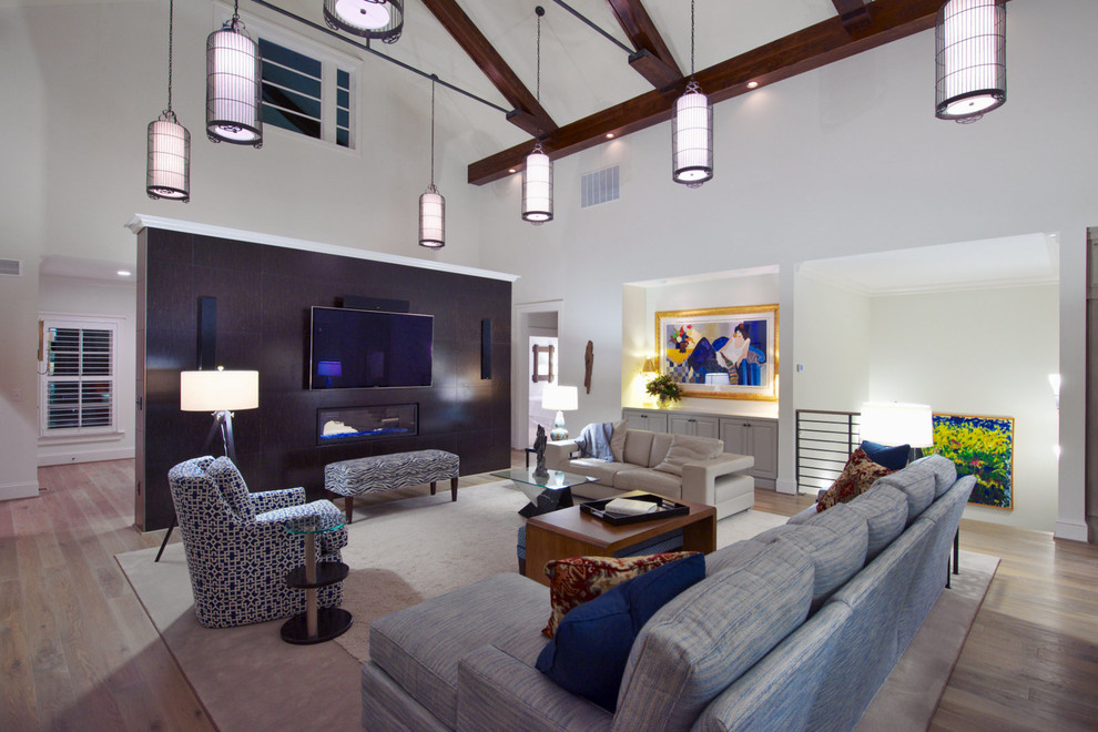 This is an example of a large contemporary formal open concept living room in Raleigh with a ribbon fireplace, white walls, medium hardwood floors, a metal fireplace surround, a built-in media wall and brown floor.