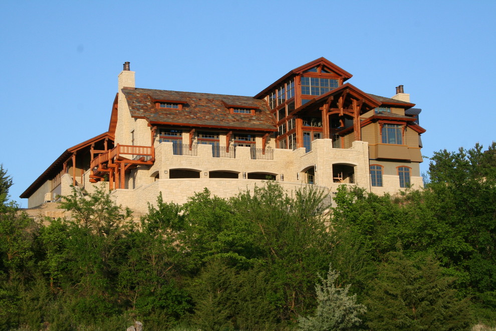 Photo of an expansive country three-storey exterior in Other with stone veneer.