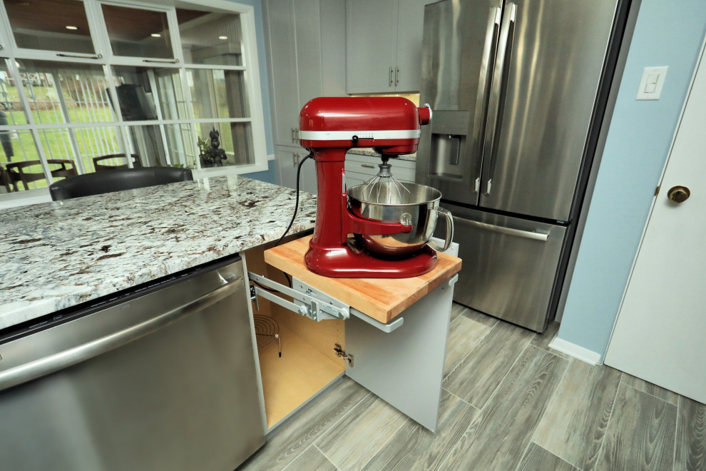 Mid-sized transitional gray floor kitchen photo with a double-bowl sink, shaker cabinets, gray cabinets, granite countertops, multicolored backsplash, porcelain backsplash, stainless steel appliances, multicolored countertops and an island