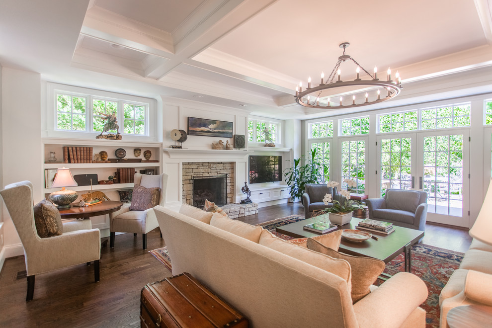 This is an example of a large transitional open concept family room in Cincinnati with white walls, dark hardwood floors, a standard fireplace, a stone fireplace surround, a wall-mounted tv and brown floor.