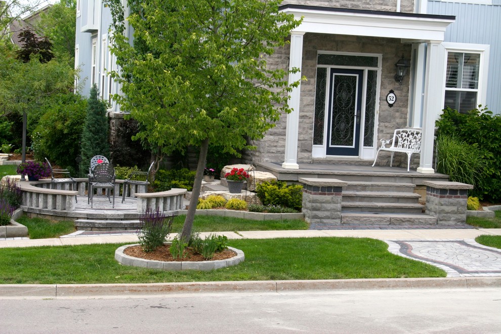 This is an example of a mid-sized transitional partial sun front yard stone driveway in Toronto for summer.