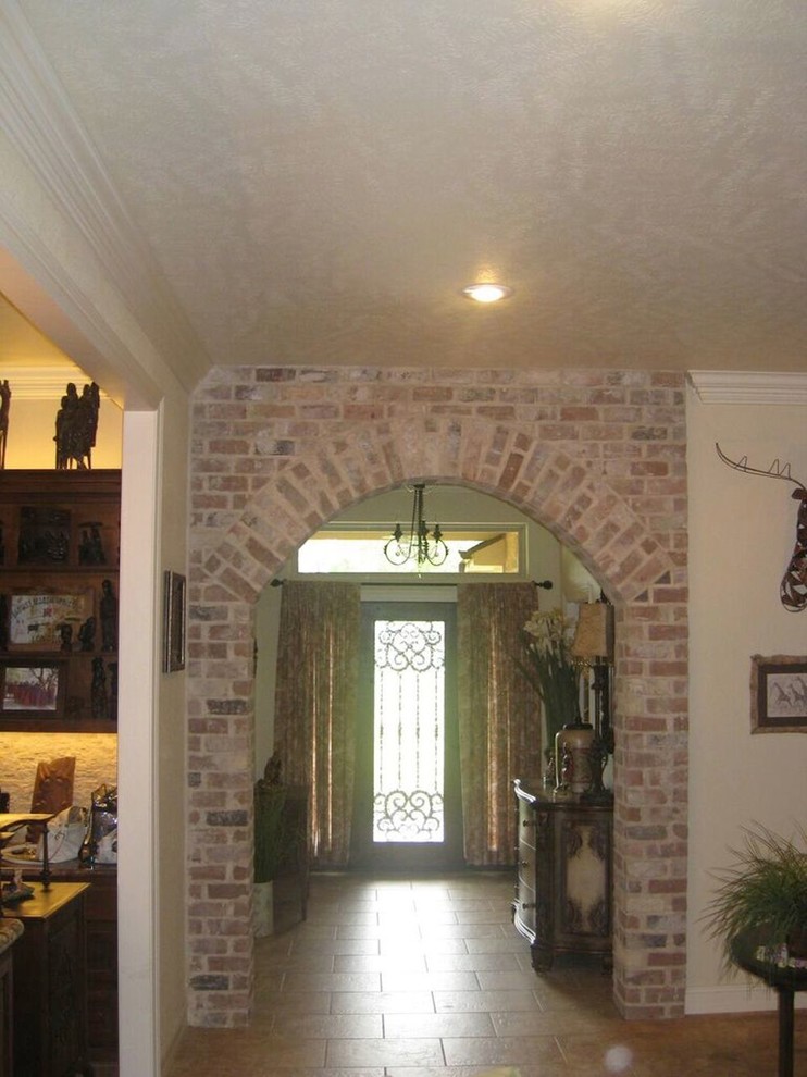 Small porcelain tile and brown floor foyer photo with beige walls and a dark wood front door