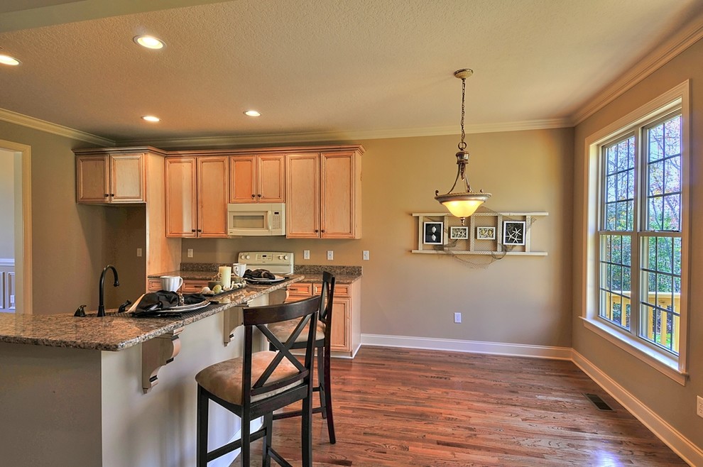 Inspiration for a transitional l-shaped eat-in kitchen remodel with an undermount sink, flat-panel cabinets, light wood cabinets, granite countertops and colored appliances