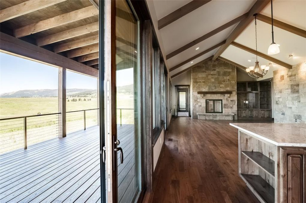 Inspiration for a large transitional galley dark wood floor, brown floor and vaulted ceiling open concept kitchen remodel with a drop-in sink, raised-panel cabinets, medium tone wood cabinets, granite countertops, multicolored backsplash, stainless steel appliances, an island and white countertops