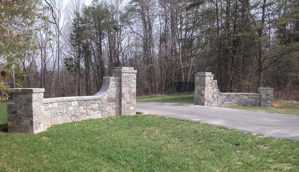 Granite stone free standing wall at entrance to driveway. Design and built by Peter Atkins and Associate