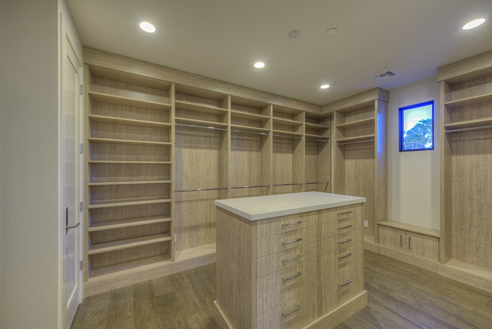 Inspiration for a mid-sized modern gender-neutral walk-in wardrobe in Phoenix with flat-panel cabinets, light wood cabinets, light hardwood floors and brown floor.