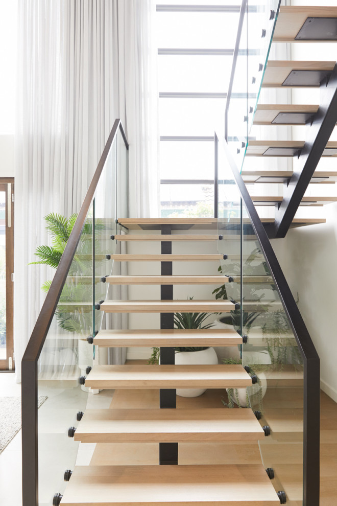 На фото: большая п-образная лестница в современном стиле с деревянными ступенями и металлическими перилами без подступенок с