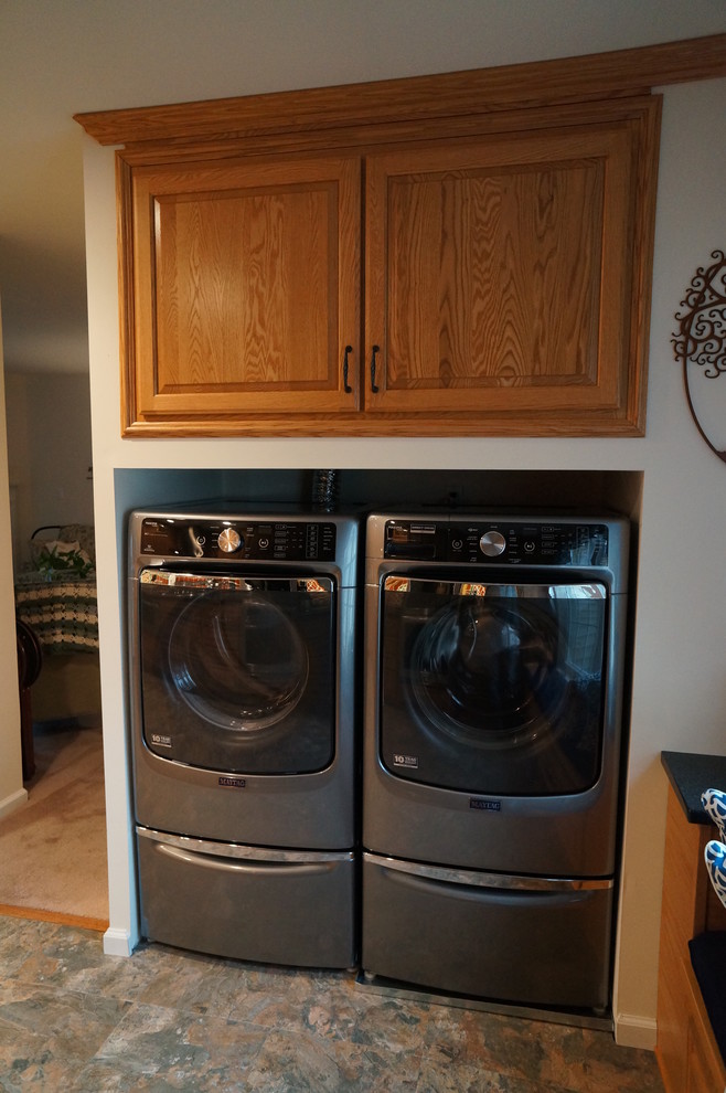 This is an example of a small l-shaped laundry room in Philadelphia with an undermount sink, raised-panel cabinets, medium wood cabinets, quartz benchtops, brown splashback, terra-cotta splashback and linoleum floors.