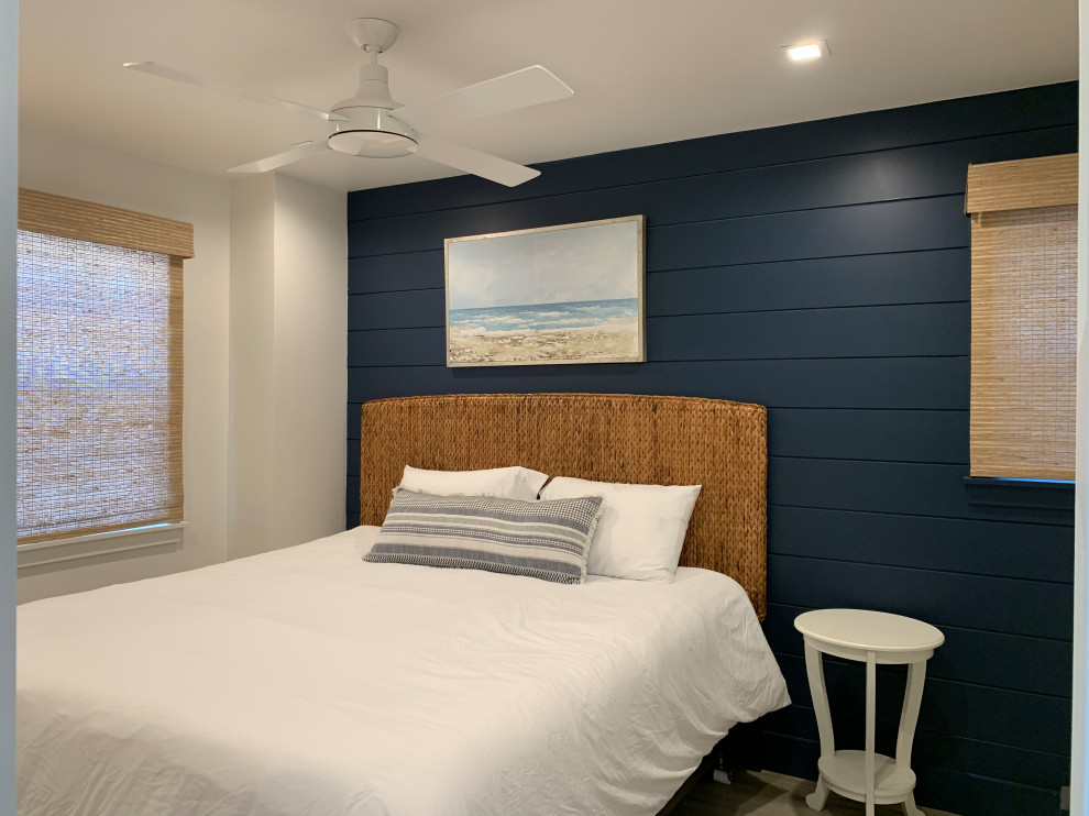 Foto di una piccola camera degli ospiti stile marinaro con pareti blu, pavimento in vinile, pavimento beige e pareti in perlinato