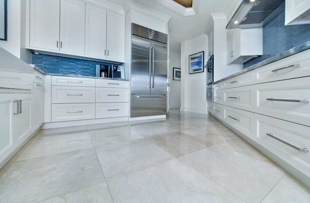 Mid-sized contemporary galley eat-in kitchen in Miami with recessed-panel cabinets, white cabinets, quartz benchtops, blue splashback, porcelain splashback, stainless steel appliances, porcelain floors, a peninsula, white floor, multi-coloured benchtop, recessed and a farmhouse sink.