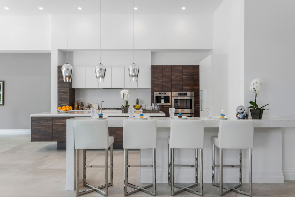 This is an example of a large contemporary galley eat-in kitchen in Miami with an integrated sink, flat-panel cabinets, white cabinets, quartzite benchtops, grey splashback, glass sheet splashback, panelled appliances, porcelain floors, multiple islands, grey floor and grey benchtop.