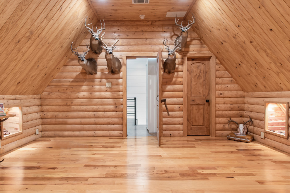 Mittelgroßes, Abgetrenntes Rustikales Wohnzimmer mit braunem Holzboden, Eckkamin, Kaminumrandung aus Stein, Holzdecke und Holzwänden in Dallas
