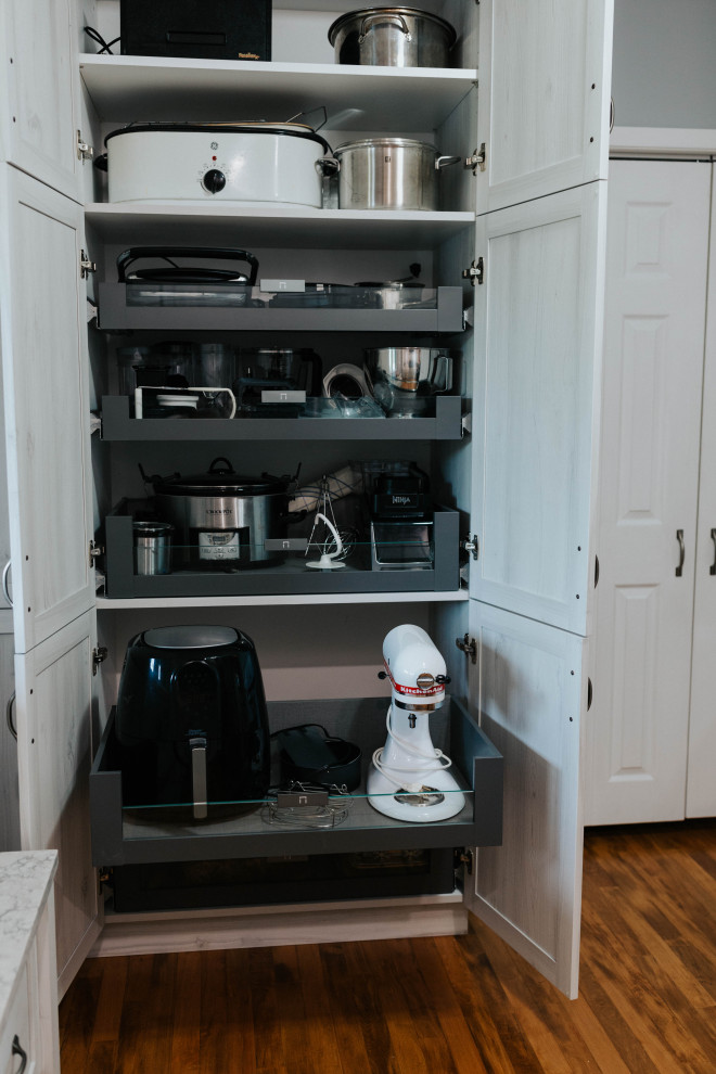 Design ideas for a mid-sized transitional utility room in Toronto with an undermount sink, shaker cabinets, grey cabinets, quartz benchtops, blue splashback, glass tile splashback, grey walls, medium hardwood floors, a side-by-side washer and dryer and grey benchtop.
