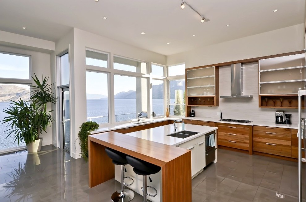 This is an example of a large contemporary u-shaped eat-in kitchen in Other with flat-panel cabinets, medium wood cabinets, white splashback, quartz benchtops, porcelain splashback, stainless steel appliances, porcelain floors, with island and an undermount sink.