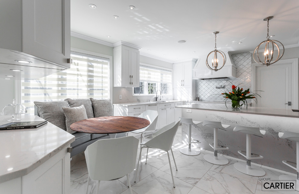 Eat-in kitchen - huge transitional l-shaped marble floor eat-in kitchen idea in Montreal with an undermount sink, shaker cabinets, white cabinets, quartzite countertops, gray backsplash, glass tile backsplash, paneled appliances and an island