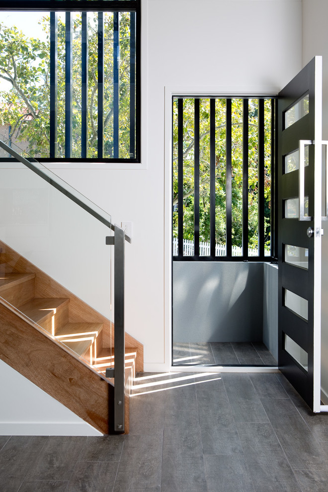 Inspiration for a modern front door in Brisbane with white walls, ceramic floors, a single front door, a black front door and grey floor.
