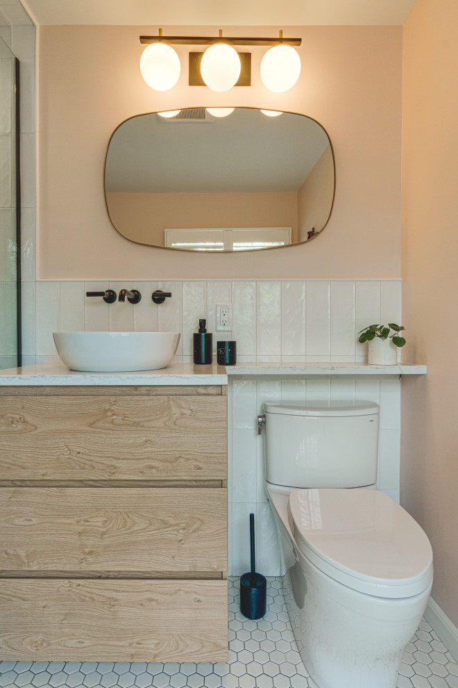 Idée de décoration pour une petite salle de bain minimaliste en bois foncé avec un placard à porte plane, une douche d'angle, WC à poser, un carrelage blanc, des carreaux de céramique, un mur rose, carreaux de ciment au sol, une vasque, un plan de toilette en quartz modifié, un sol blanc, une cabine de douche à porte battante, un plan de toilette multicolore, meuble simple vasque et meuble-lavabo suspendu.