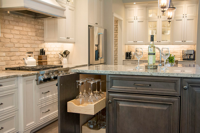 Example of a large transitional l-shaped eat-in kitchen design with a double-bowl sink, shaker cabinets, white cabinets, beige backsplash, stainless steel appliances and an island