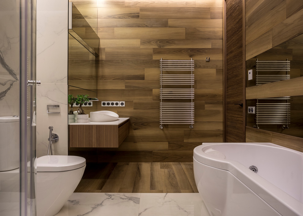 Inspiration for a mid-sized contemporary bathroom in Moscow with flat-panel cabinets, a hot tub, brown tile, porcelain tile, porcelain floors, engineered quartz benchtops, white benchtops, medium wood cabinets, a two-piece toilet, a vessel sink and brown floor.