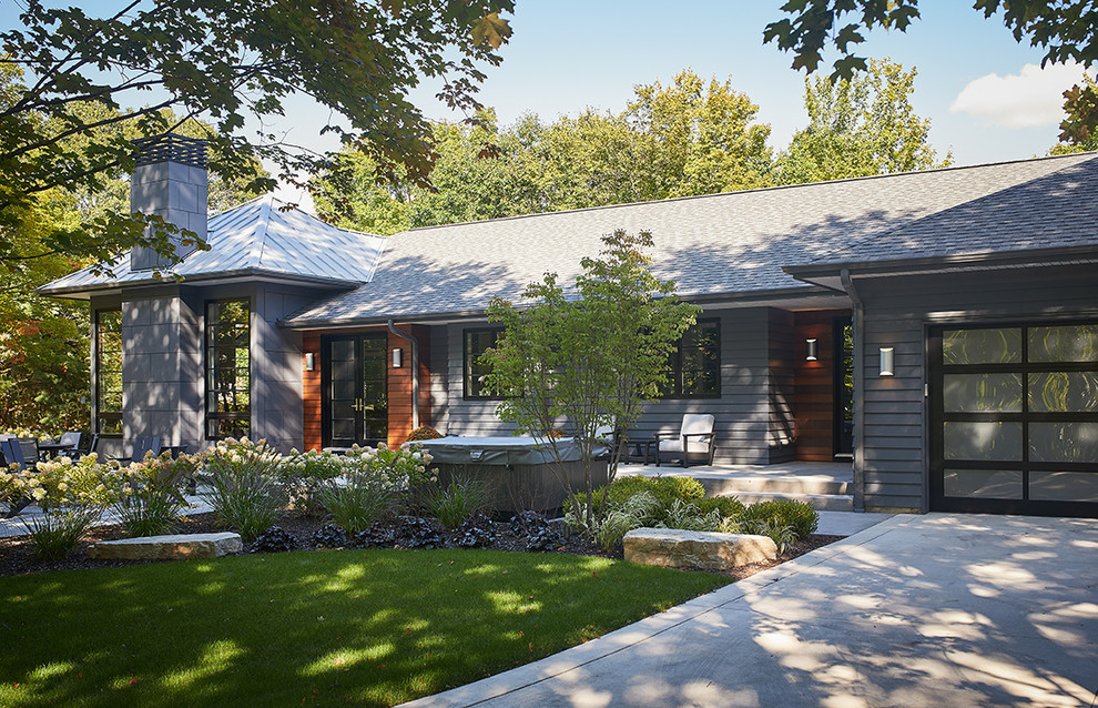 Design ideas for a modern grey house exterior in Grand Rapids with mixed siding, a hip roof and a mixed roof.