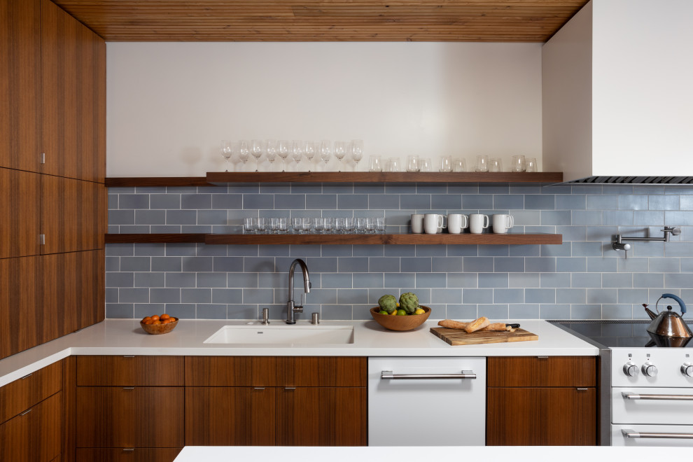 Esempio di una cucina minimal con paraspruzzi blu, paraspruzzi con piastrelle di cemento, lavello sottopiano, ante lisce, ante in legno scuro, top in superficie solida, elettrodomestici bianchi e top bianco