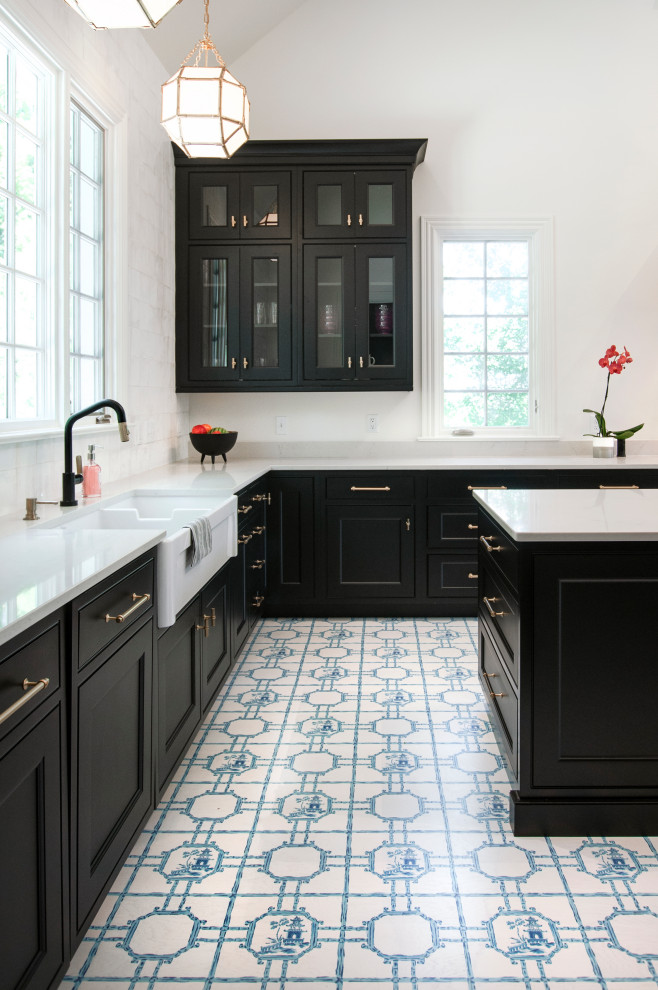 This is an example of an expansive classic u-shaped kitchen/diner in Nashville with a belfast sink, beaded cabinets, black cabinets, engineered stone countertops, white splashback, ceramic splashback, integrated appliances, painted wood flooring, an island, blue floors and white worktops.