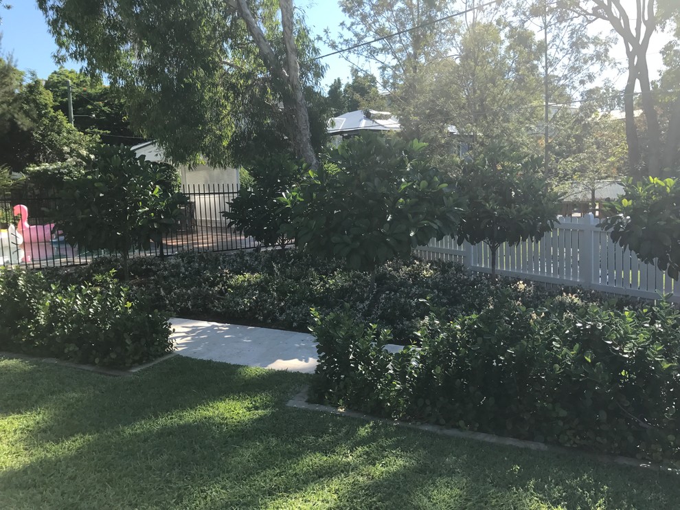 На фото: большой летний регулярный сад на переднем дворе в классическом стиле с садовой дорожкой или калиткой, полуденной тенью и покрытием из каменной брусчатки